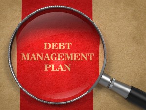 Debt Management Plan. Magnifying Glass on Old Paper with Red Vertical Line.
