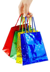 colorful shopping bags set in woman's hand isolated on white