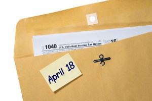 Printed copy of Form 1040 for income tax return with reminder for April 18 deadline